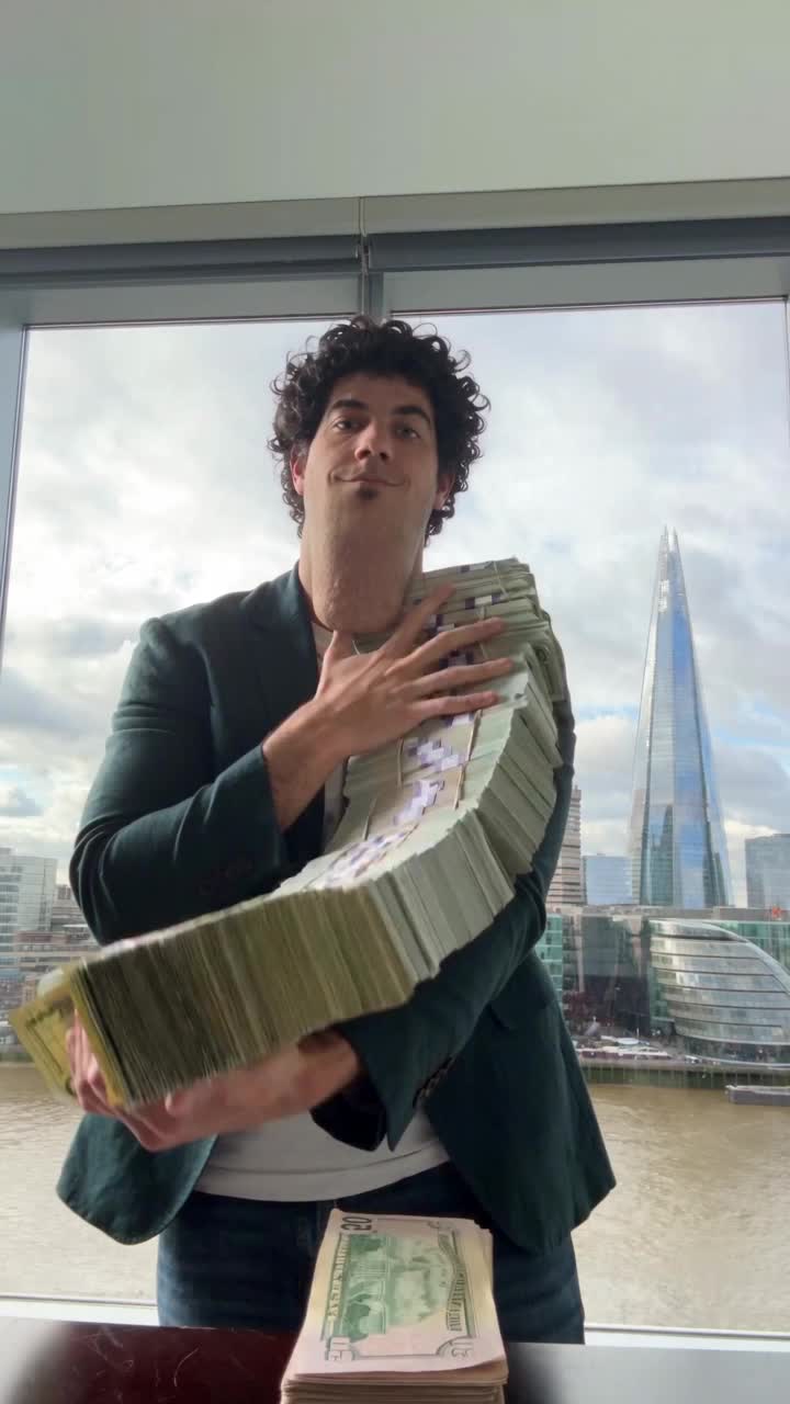 Alon parody holding a ridiculous stack of cash by a London window